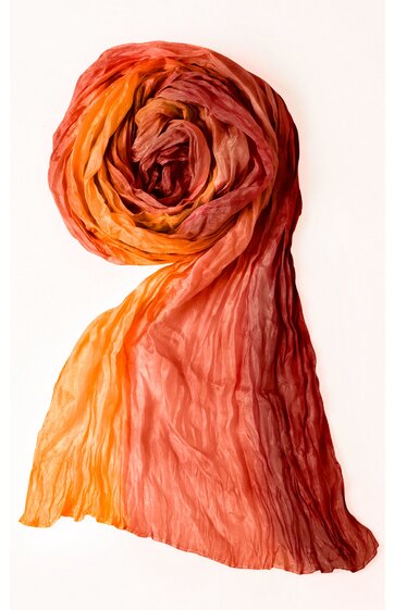 Schal in orange und rot mit Farbverlauf, leicht transparent, gekräuselt und locker zusammengerollt, rechteckig, weiche Struktur sichtbar