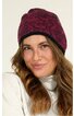 Dunkelrote Beanie-Mütze mit schwarzem Blumenmuster, schwarzer Umschlagkante, getragen von lächelnder Frau mit langen, welligen, hellbraunen Haaren, weißer Rollkragenpullover