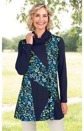 Dunkelblaue Tunika mit asymmetrischem Blumenmuster in Hellblau, Hellgrün und Weiß, Rollkragen, lange Ärmel, gerade geschnitten, getragen von stehender Frau mit rechter Hand am Kragen