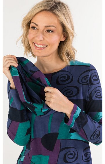 Langärmeliges Oberteil in dunklem Blau mit abstraktem Muster in Schwarz, Grün und Lila, hoher Halsausschnitt, getragen von lächelnder Frau, locker sitzend