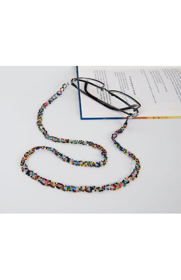 Brillenband mit bunten Perlen in verschiedenen Farben, geflochten, mit schwarzen Silikonhaltern an beiden Enden, auf weißem Hintergrund liegend, über Teil eines aufgeschlagenen Buches gelegt