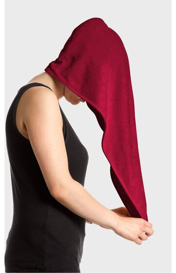 Schwarzes ärmelloses Oberteil, getragen von seitlich abgewandter Person, rotes, langes Handtuch auf dem Kopf, Person hält Handtuchenden mit ausgestreckten Armen fest