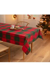 Rechteckige Tischdecke in Rot und Grün kariert mit Tannenbaum-Motiv, auf hellem Holztisch, daneben zwei helle Holzstühle, weihnachtliche Dekoration im Hintergrund, Tasse und Teller mit Gebäck auf der Tischdecke