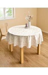 Runder Tisch mit hellbeigem Tischdeckenüberzug mit floralem Muster, vierkantige Holzbeine, auf Holzboden, mit heller Holzstuhl, darauf graue Kerze und weiße Vase mit getrockneten Blumen