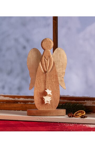 Holzengel-Figur in heller und mittlerer Holzfarbe, stilisiert, stehende Form mit vereinfachtem Kopf, Flügel, hängende Sterne, runde Basis, dekorativ auf Fensterbank mit rotem Stoff und Tannenzweig im Hintergrund