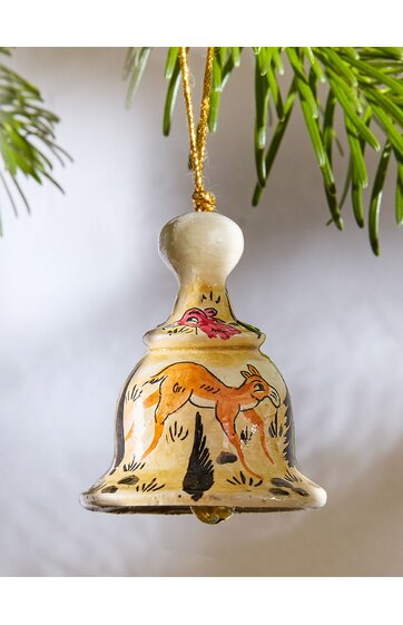 Glockenförmiger Weihnachtsbaumschmuck in cremeweiß mit orangefarbenem Fuchs, schwarzem Vogel, grünem Laub, goldfarbenem Aufhängfaden, handbemalt