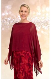 Rotes Abendkleid mit abstraktem Muster, darüber liegender transparenter roter Überwurf mit weiten Ärmeln, getragen von stehender Frau, knielang, locker fallend