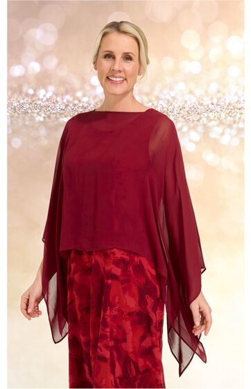 Rotes Abendkleid mit abstraktem Muster, darüber liegender transparenter roter Überwurf mit weiten Ärmeln, getragen von stehender Frau, knielang, locker fallend