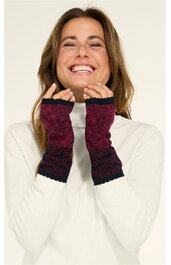 Paar handgestrickte pulswärmer in dunkelrot mit schwarzem Spitzenmuster, über die Handgelenke gezogen, getragen von lächelnder Frau in weißem Langarmshirt, fingerlose Handschuhe ohne Daumenöffnung