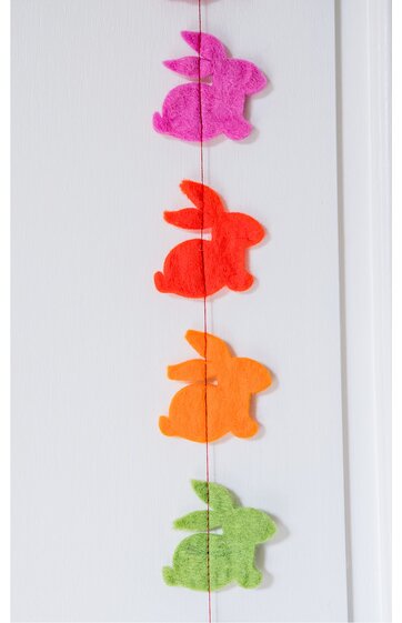 Deko-Girlande mit vier Kaninchenfiguren in Pink, Rot, Orange, Hellgrün, flache Form, an einer dünnen Schnur hängend, vor weißem Hintergrund