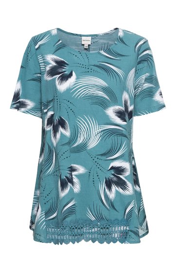 Damenbluse in türkis mit weiß-schwarzem Blumenmuster, Rundhalsausschnitt, kurze Ärmel, lockere Passform, Saum mit Spitzenbesatz