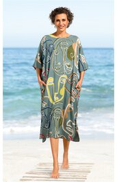 Grünes Midikleid mit abstraktem Gesichter- und Linienmuster in Gelb, Hellgrün, Beige, locker geschnitten, kurze Fledermausärmel, Rundhalsausschnitt, knielang, getragen von stehendem barfußem Modell am Strand