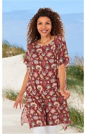 Rotes, knielanges Kleid mit weißem und gelbem Blumenmuster, rundem Ausschnitt, halblangen Ärmeln, locker sitzend, getragen von stehender Frau am Strand