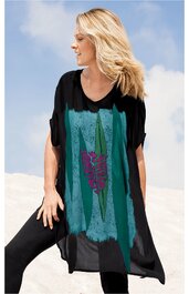 Schwarzes, lockeres Tunika-Kleid mit großflächigem türkisfarbenem Muster, violetter Blütenaufdruck in der Bildmitte, rundem Ausschnitt, kurze Fledermausärmel, getragen von seitlich stehendem weiblichem Modell