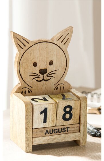 Holzkalender mit Katzenkopf oben, naturfarbig, schwarze Konturzeichnung des Katzengesichts, zwei Würfel mit Zahlen, darunter ein länglicher Block mit Monatsnamen August, rechteckige Form