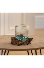 Trinkglas klar mit leicht grünem Stich, rund, auf brauner Holzunterlage mit unregelmäßiger, naturnaher Form, ohne Henkel, auf rundem Holztisch