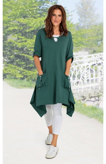 Dunkelgrünes, asymmetrisches Damenkleid mit Dreiviertelärmeln, Rundhalsausschnitt, seitlichen Taschen mit Schleifendetails, getragen von stehender Frau, locker fallend