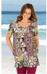 Kurzärmliges Tunika-Shirt in gemusterten Braun-, Grün- und Beigetönen, gemischtes geometrisches und florales Muster, Rundhals, lockere Passform, getragen von lächelnder Frau am Strand stehend, mit Taschen