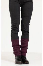 Beinwärmer in dunklem bordeauxrot mit Rippenstrickmuster, lang und leger, getragen über schwarzen engen Hosen, kombiniert mit schwarzen Schnürschuhen