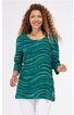 Grün-blau gemustertes Tunikaoberteil mit wellenförmigem Design, Rundhalsausschnitt, dreiviertellangen Ärmeln, seitlichen Schlitzen, getragen von stehender Frau