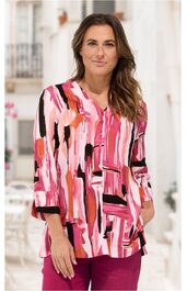 Bluse in Pink- und Rottönen mit abstraktem Mustermix in Schwarz und Weiß, V-Ausschnitt, 3/4-Ärmel, lockere Form, getragen von stehender Frau