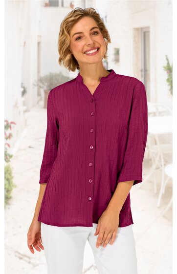 Damenbluse in dunklem Beerenrot, unifarben, stehkragen, lange Knopfleiste mit kleinen Knöpfen, 3/4-lange Ärmel, getragen von lächelnder stehender Frau, locker geschnitten