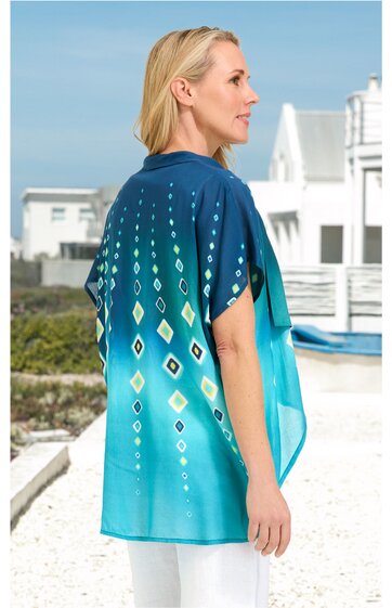 Tunika in Türkis mit dunkelblauen und hellgelben Rautenmuster, kurze Ärmel, Rundhalsausschnitt, gerade geschnitten, getragen von seitlich stehender Frau