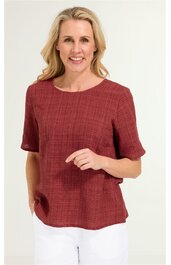 Kurzärmeliges Damenoberteil in ziegelrot mit feinem Karomuster, rundem Halsausschnitt, locker geschnitten, getragen von stehender Frau mit langen blonden Haaren