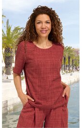 Rundhalsausschnitt Bluse in rostrot mit Karomuster, halblange Ärmel, gerade geschnitten, getragen von stehender Frau mit Händen in den seitlichen Taschen, lässige Passform