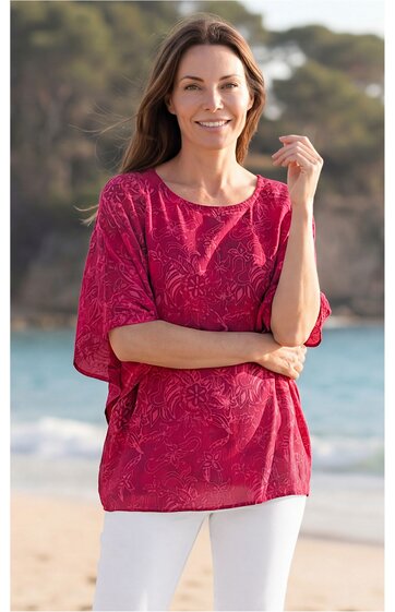 Rotes T-Shirt mit floralen Mustern, Rundhalsausschnitt, halblange Ärmel, gerade geschnitten, getragen von stehender Frau am Strand