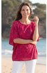 Rotes T-Shirt mit floralen Mustern, Rundhalsausschnitt, halblange Ärmel, gerade geschnitten, getragen von stehender Frau am Strand