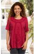 Rotes Kurzarmshirt mit floralem Muster vorne, Rundhalsausschnitt, locker geschnitten, getragen von stehender Frau mit lockigen Haaren