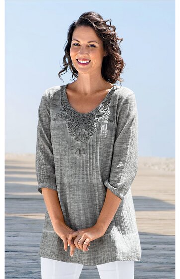 Graue Damenbluse mit floralem Stickmuster am Rundhalsausschnitt, 3/4-Ärmel, gerade geschnitten, getragen von lächelnder Frau in stehender Position