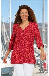 Rotes Longshirt mit orangem Blumenmuster, V-Ausschnitt, Drei-Viertel-Ärmel, gerade geschnitten, getragen von lächelnder stehender Frau vor Hafen mit Segelbooten