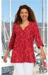 Rotes Longshirt mit orangem Blumenmuster, V-Ausschnitt, Drei-Viertel-Ärmel, gerade geschnitten, getragen von lächelnder stehender Frau vor Hafen mit Segelbooten