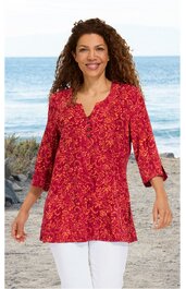 Rotes Langarmshirt mit gelbem Blumenmuster, V-Ausschnitt mit Knopfleiste, locker geschnitten, getragen von lächelnder Frau im Stehen am Strand