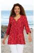 Rotes Langarmshirt mit gelbem Blumenmuster, V-Ausschnitt mit Knopfleiste, locker geschnitten, getragen von lächelnder Frau im Stehen am Strand