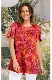 Rotes T-Shirt mit orangenen und pinken Spiralmustern, Rundhalsausschnitt, kurze Ärmel, gerade geschnitten, getragen von lächelnder Frau im Stehen