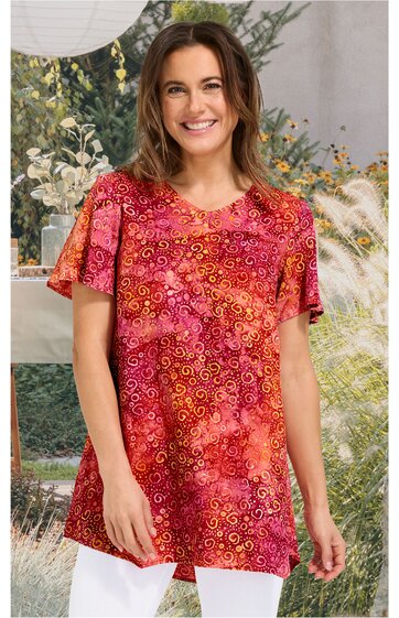 Rotes T-Shirt mit orangenen und pinken Spiralmustern, Rundhalsausschnitt, kurze Ärmel, gerade geschnitten, getragen von lächelnder Frau im Stehen