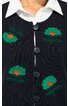 Dunkelblaue Strickjacke mit grünen gestickten Blumen mit orangenem Zentrum, Rundhalsausschnitt, vier schwarze Knöpfe, weißes Hemd mit spitzem Kragen darunter, Vorderseite sichtbar