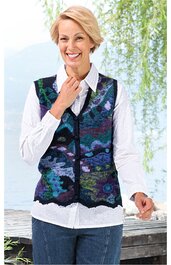 Ärmellose Weste mit abstraktem Muster in Blau, Grün und Schwarz, V-Ausschnitt, durchgehender Reißverschluss, gerader Saum, getragen von lächelnder Frau mit weißer Bluse und blauen Hosen, entspannte Pose