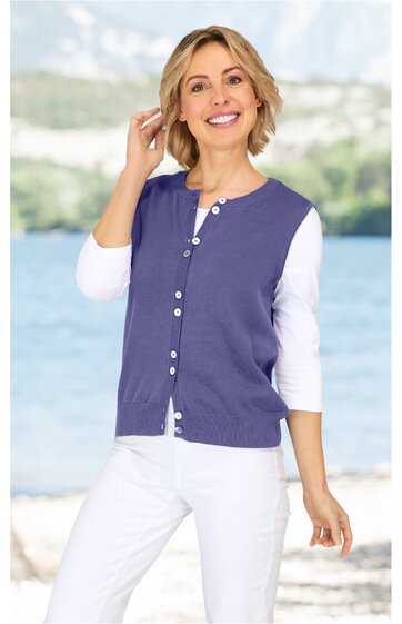 Damenweste in violett, ohne Muster, Rundhalsausschnitt, durchgehende Knopfleiste, getragen von lächelnder Frau, weiße Dreiviertelarmbluse, weiße Hose