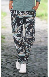 Hose in Schwarz, Hellblau und Beige mit abstraktem Muster, gerade geschnittener Bund, seitliche Eingrifftaschen, getragen von stehender Person, normales Beinmaß, weiße Sportschuhe