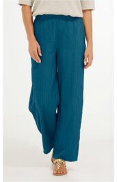 Weite Hose in dunkelpetrol, glatter Stoff, hoher elastischer Bund, gerade geschnitten, getragen von Person stehend mit weißen Sandalen