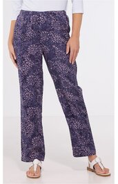 Lange Hose in dunklem Violett mit hellrosa und weißen floralen Mustern, gerader Schnitt, elastischer Bund, getragen von stehender Person, offene Zehentrenner als Schuhwerk