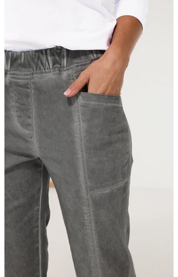 Graue Hose mit elastischem Taillenbund, seitliche Eingrifftasche, angesetzte Naht, getragen von stehender Person mit rechter Hand in Tasche