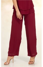 Damenhose in bordeauxrot, weit geschnitten, gerade geschnittene Beine, hoher Sitz, getragen von stehender Frau, kombiniert mit passendem Oberteil und offenen Sandaletten mit Absatz