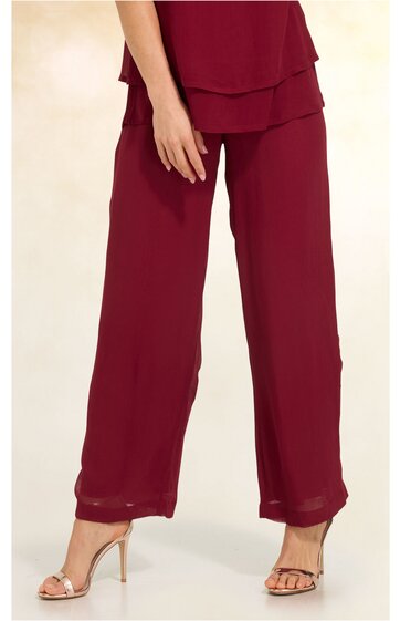 Damenhose in bordeauxrot, weit geschnitten, gerade geschnittene Beine, hoher Sitz, getragen von stehender Frau, kombiniert mit passendem Oberteil und offenen Sandaletten mit Absatz