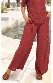 Rostbraunes zweiteiliges Outfit mit feinem Karomuster, kurzärmeliges Oberteil mit Rundhalsausschnitt, weite lange Hose, getragen von stehender Person, helle Sandalen, Hände in den Hosentaschen