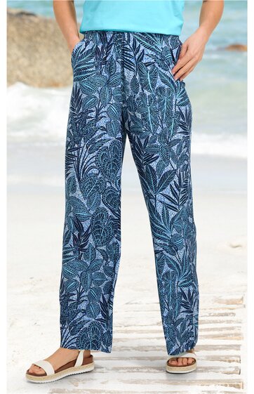 Locker geschnittene lange Hose in Blautönen mit dunkelblauem Blätter- und Pflanzenmuster, elastischer Bund, gerade geschnitten, getragen von stehender Person, geeignet für Freizeit
